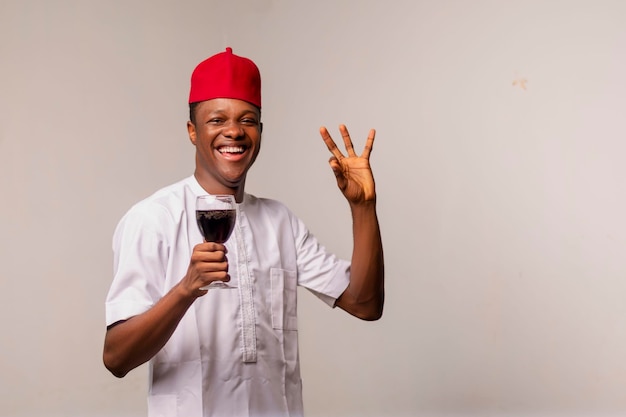 A man in a red hat holding a glass of wine