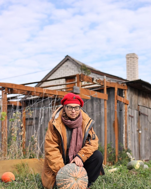 Photo a man in a red hat sits in front of a wooden house