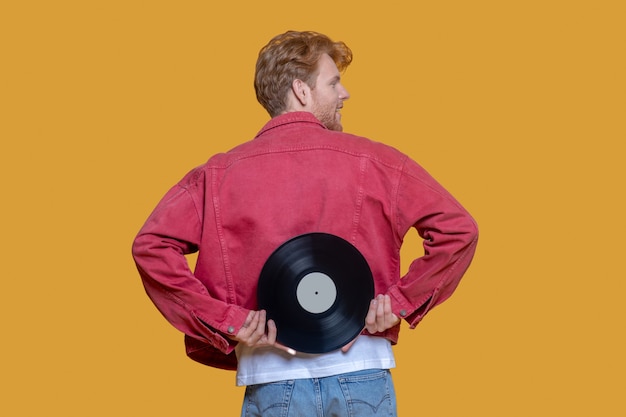 Man in red jacket with a record isolated