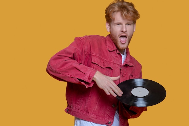 Man in red jacket with a record isolated