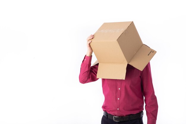 Man in a red shirt with a cardboard box on his head makes a gesture with his hands