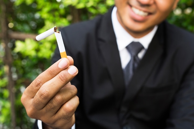 Man refusing cigarettes concept for quitting smoking and healthy lifestyle dark.