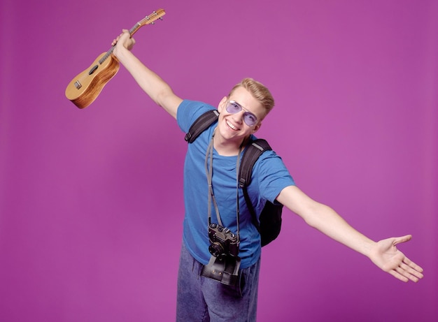 Man reiziger met camera en gitaar ukulele op paarse achtergrond