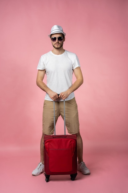 Man reiziger met koffer, paspoort en ticket op kleur achtergrond.