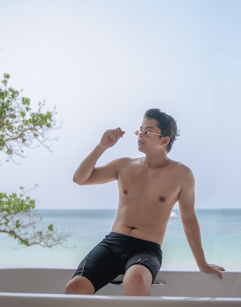 Man relaxing in the bathtub with beach ocean background.