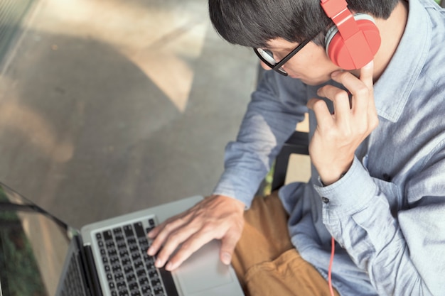 Foto uomo che si rilassa ascoltando musica dal computer portatile
