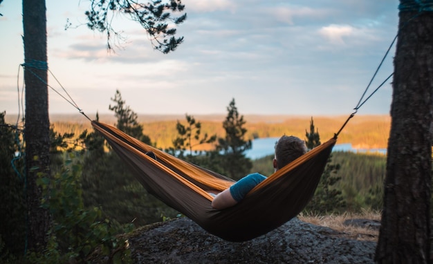 Man relaxing on hammock against landscape