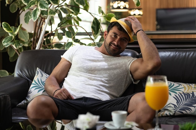 Man Relaxing on Sofa in Hotel Lobby Bar