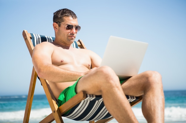 Man relaxing and using laptop