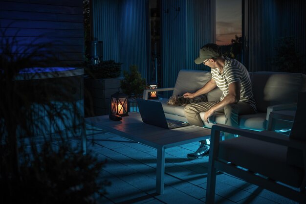 Man Remotely Working on a Laptop Computer From His Patio