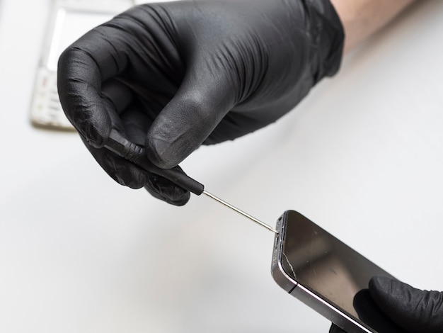 Photo man removing screws from a phone