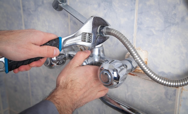 Photo man repair and fixing shower faucet in bathroom