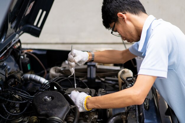 Man repair and maintenance engine of the old car. concept of\
safe driving and automobile care.