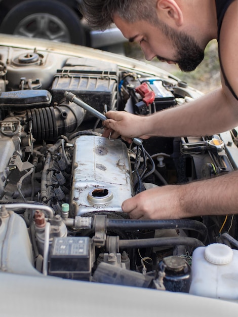 Man repairing 4g13 engine on a street in garage