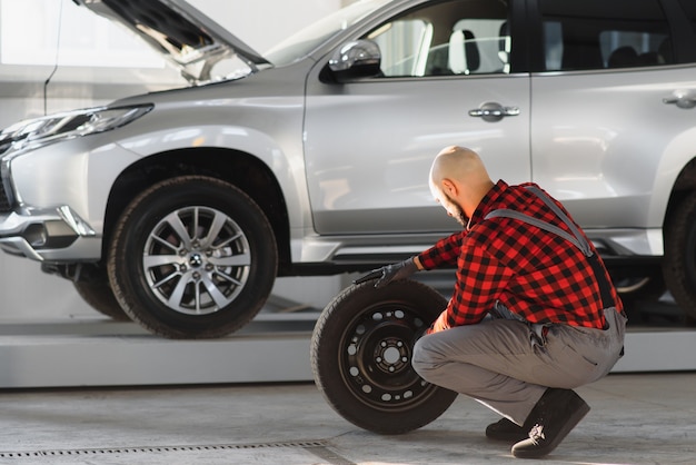 写真 ガレージで車のホイールを修復する男