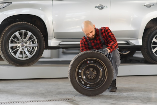 写真 ガレージで車のホイールを修復する男