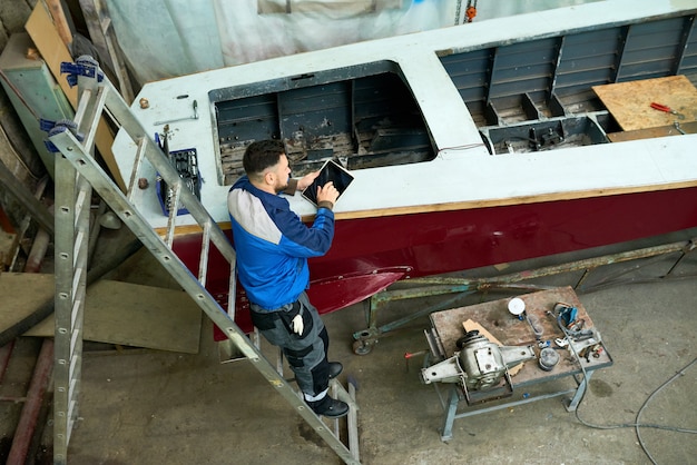 Man Repairing Boats in Customs Workshop