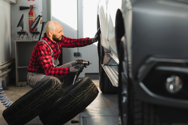 Photo man repairing a car wheel in a garage