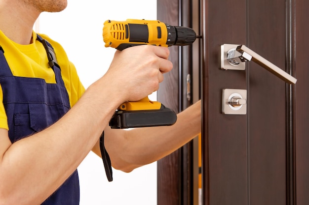 A man repairing a doorknob handyman repair the door lock in the room