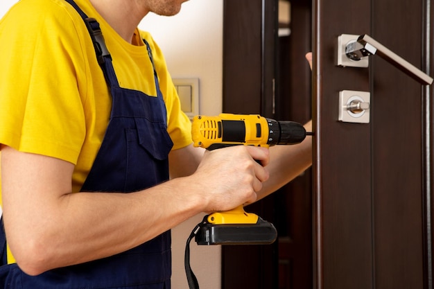 A man repairing a doorknob handyman repair the door lock in the room