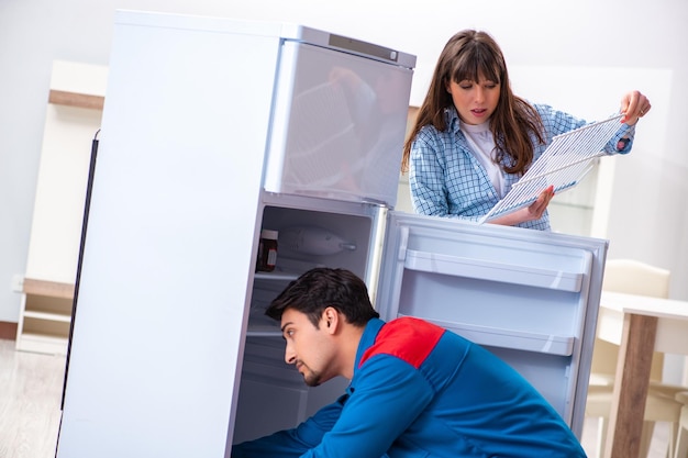 Foto uomo che ripara il frigorifero con il cliente