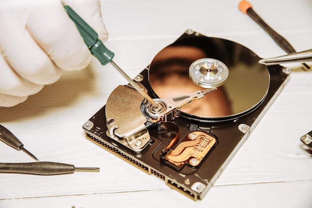 Photo man repairing hard disk inside details of the old personal computer broken pc screwdriver in hands