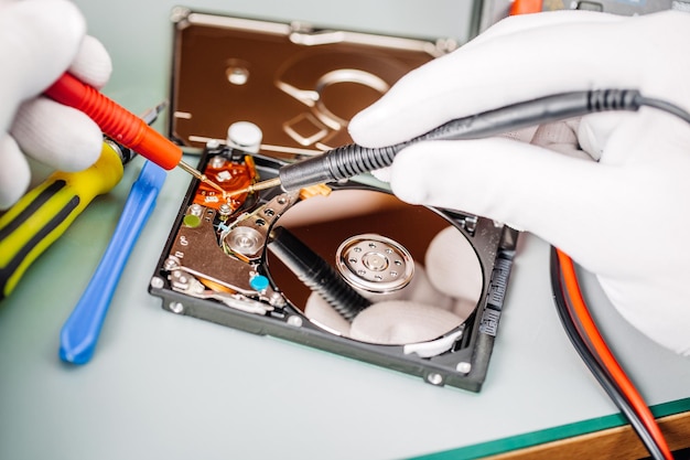 Uomo che ripara il disco rigido nel centro di assistenza servizio di riparazione e fissaggio in laboratorio concetto di servizio di riparazione elettronica