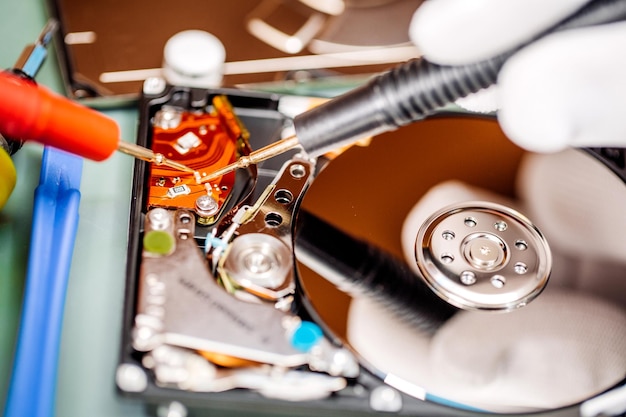 Man repairing hard drive in service center repairing and fixing\
service in lab electronics repair service concept