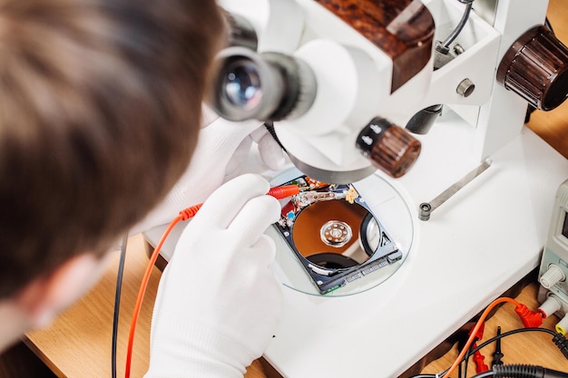 Man repairing hard drive in service center Repairing and fixing service in lab Electronics repair service concept