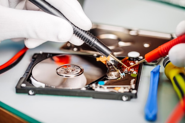 Man repairing hard drive in service center repairing and fixing\
service in lab electronics repair service concept