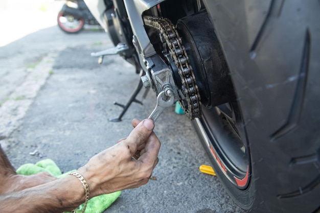 Man repairing motorcycle chain Sport Hobby