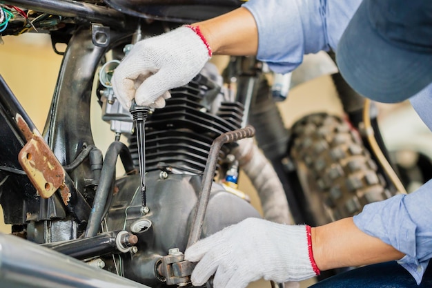 Man repairing motorcycle in repair shop Mechanic fixing motorbike in workshop garage Repairing and maintenance concepts