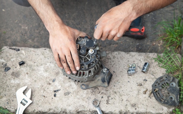 Man repairs car alternator Technology Industry