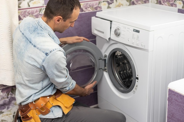 man repairs a washing machine.