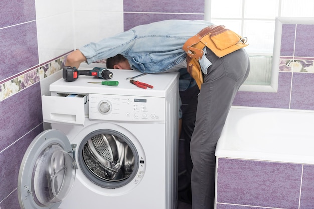 man repairs a washing machine.