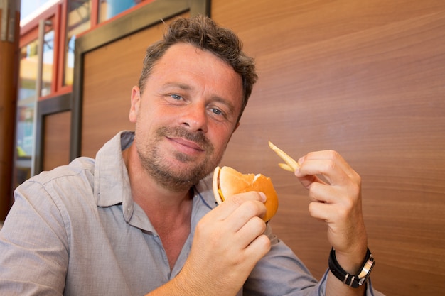 Man in restaurant eating a hamburger