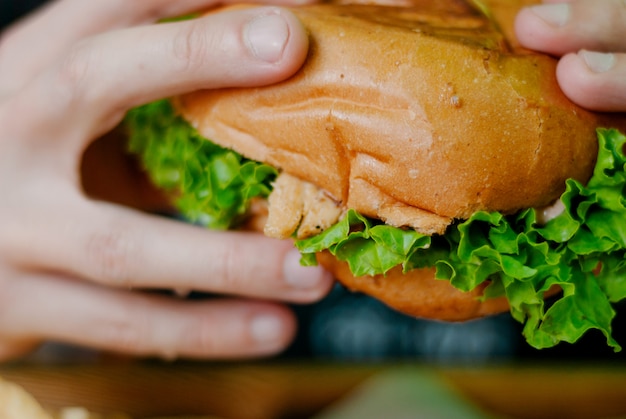 Uomo in un ristorante che mangia un hamburger