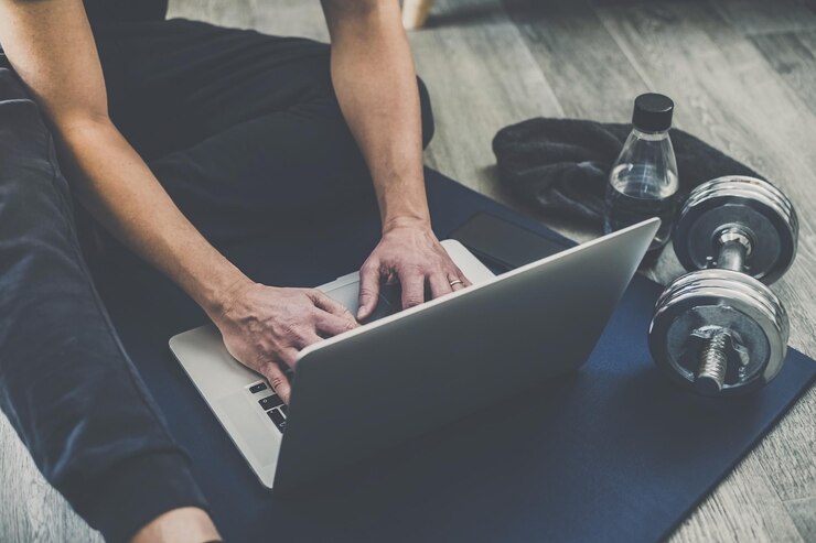 Photo man resting after working out at home boy looking online gym exercise video on laptop computer