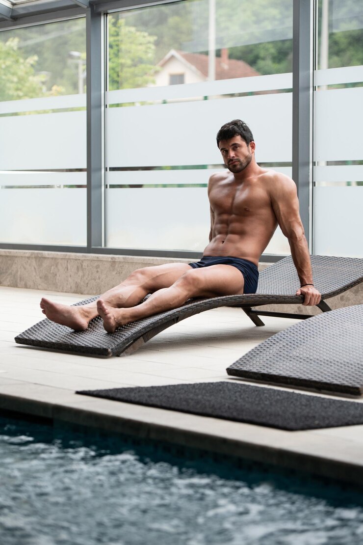 Photo man resting on sun loungers by swimming pool