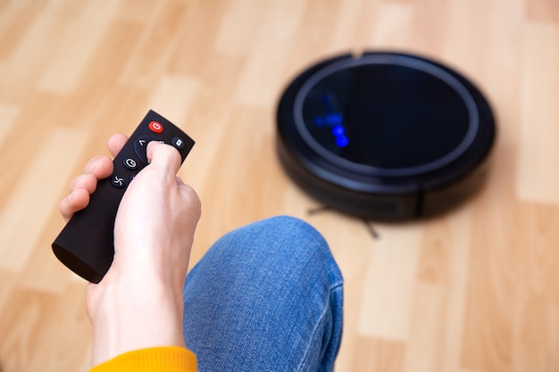 Photo man resting while robotic vacuum cleaner doing chores, clean work at home