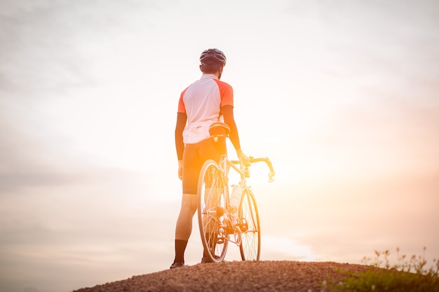 Un uomo in bicicletta sulla montagna uomo in sella a una bici sportiva vintage per l'esercizio serale