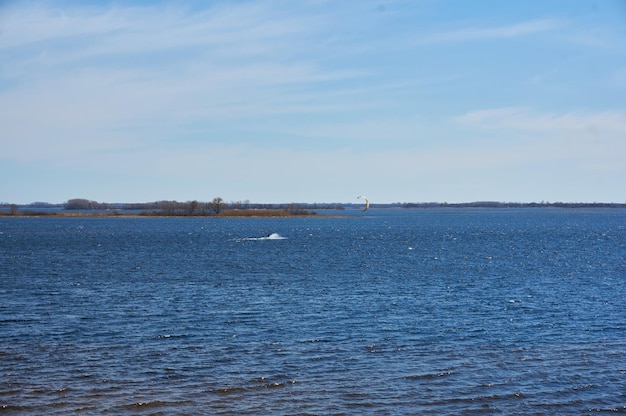 A man rides a board under sail on the river