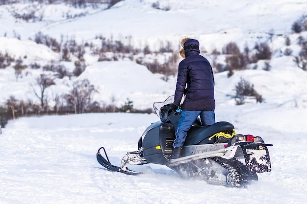 写真 雪原をスノーモービルに乗る男