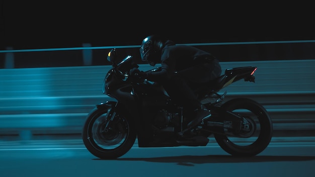 A man rides a sports motorcycle through the city at night