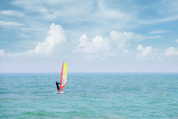 L'uomo cavalca il windsurf sulle onde del mare