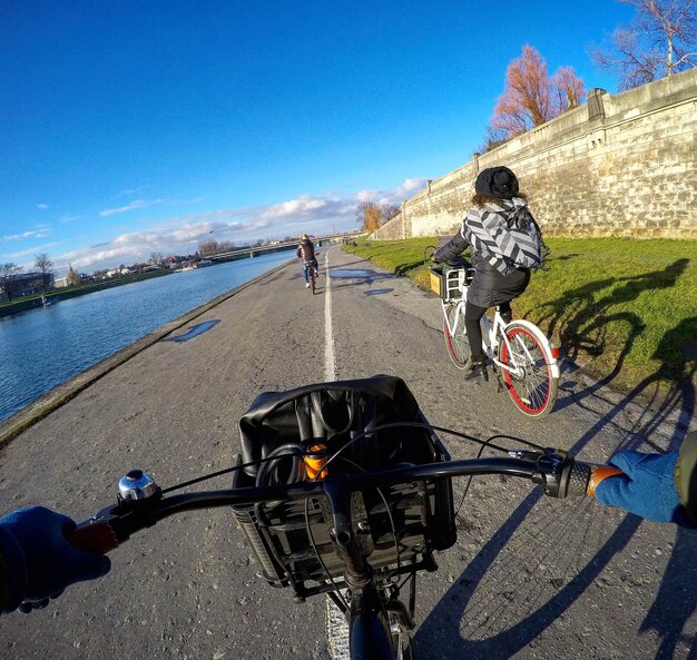 写真 青い空に背を向けて自転車に乗っている男