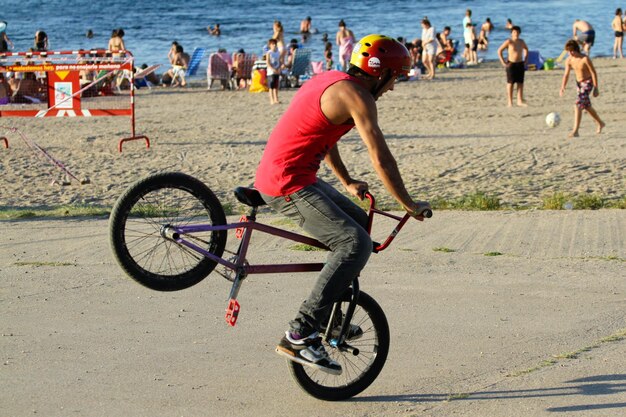 Foto uomo in bicicletta sulla spiaggia