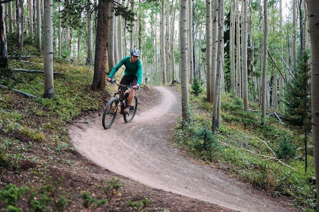 man riding bicycle in forest