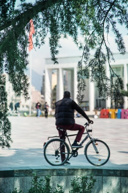 Фото Мужчина едет на велосипеде по улице в городе