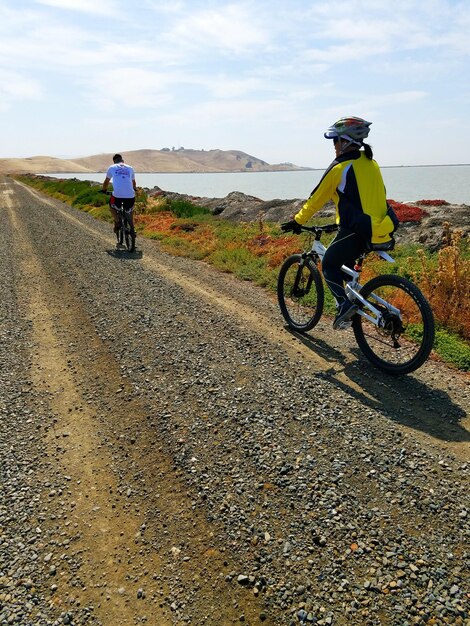 空の向こうの道路で自転車に乗っている男